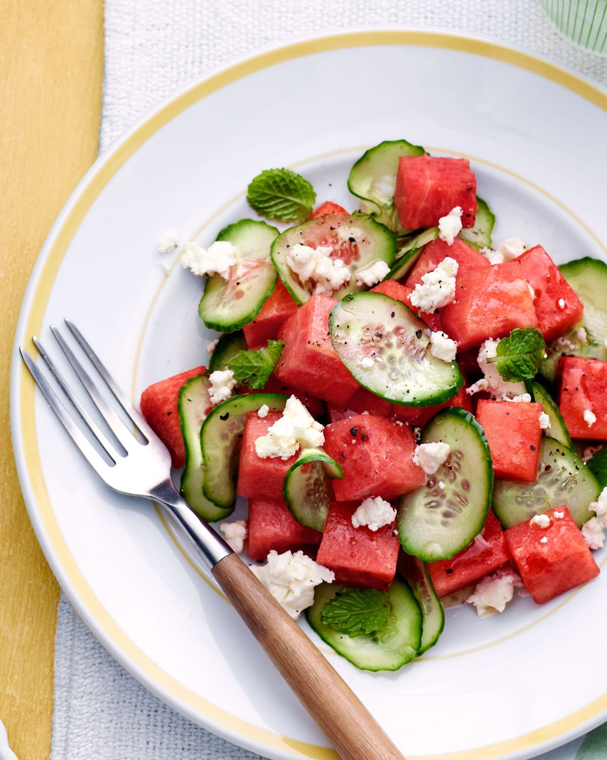 watermelon cucumber salad on a plate with a vintage fork