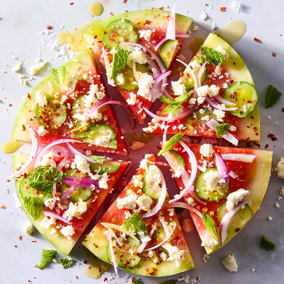 watermelon slices topped with red onion, sliced cucumbers, feta, and mint
