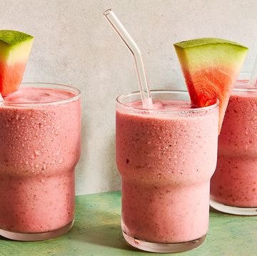watermelon smoothie in a glass with a straw and a watermelon garnish