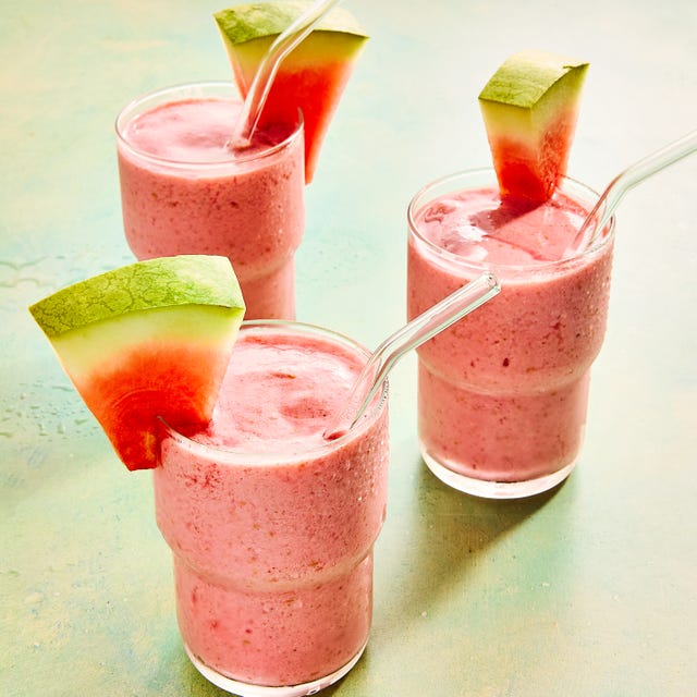 watermelon smoothie in a glass with a straw and a watermelon garnish