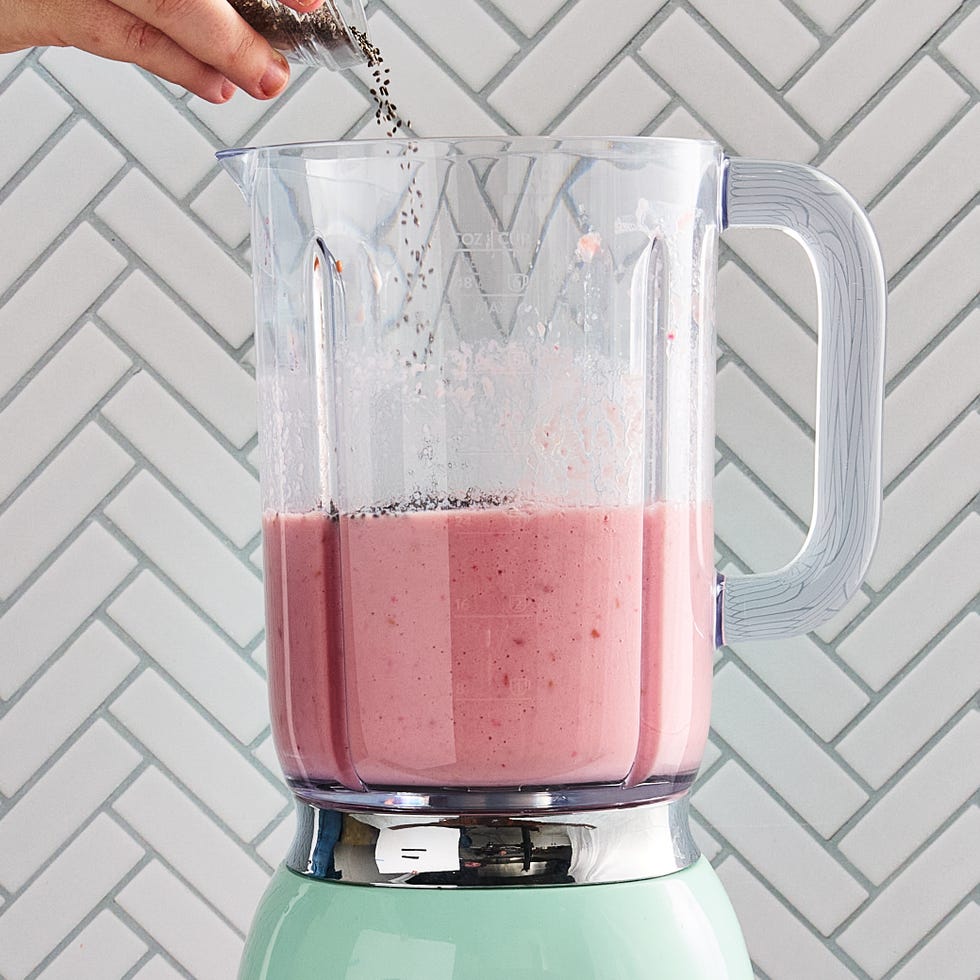 watermelon smoothie in a glass with a straw and a watermelon garnish