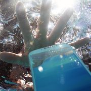 hand reaching for phone dropped in pool