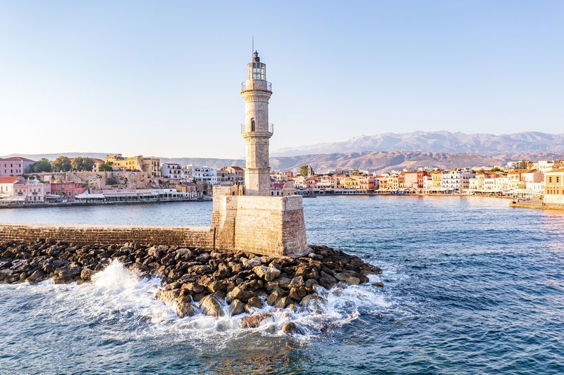 waves crashing on lighthouse, chania, crete, greece