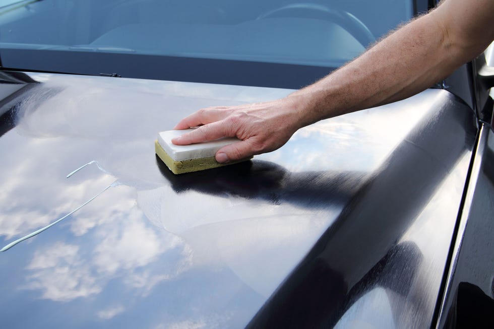 polishing a blue car with machine