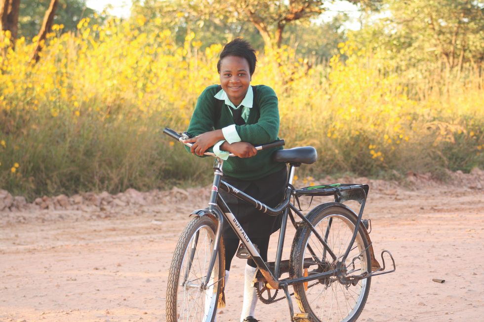 a recipient with her donated "buffalo bike" from world bicycle relief