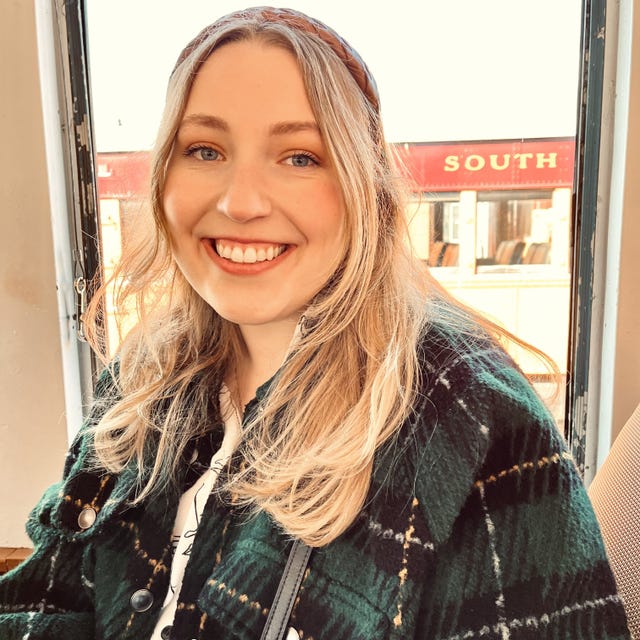 person wearing a green plaid jacket in a bright indoor setting