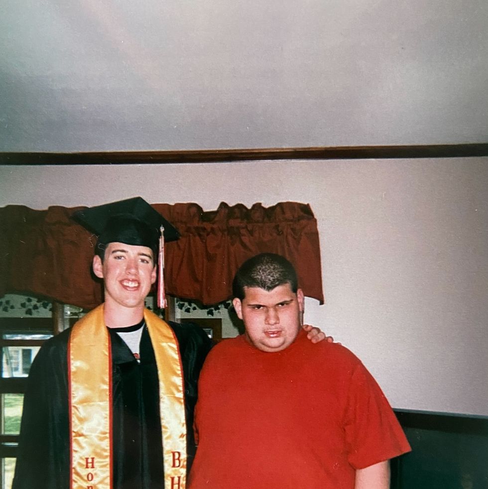 tony poses with alex in his graduation cap and gown