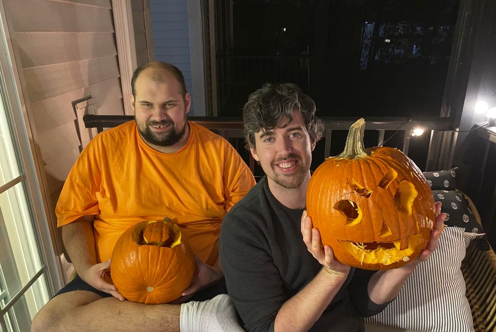alex and tony show off their carved pumpkins on the porch