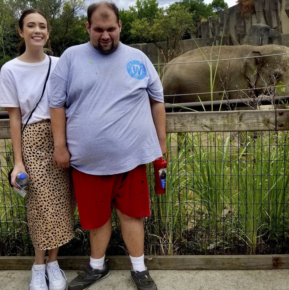 amanda and tony pose with an elephant in the background