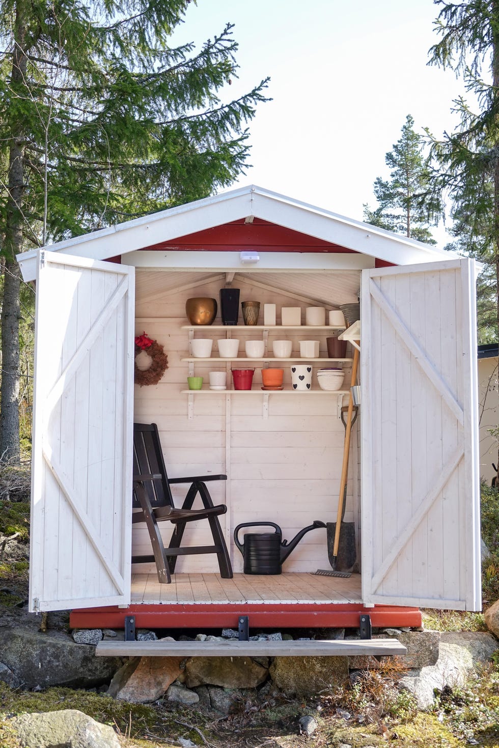 storage shed filled with garden tools. shovels, rake, pots, water pitcher and all you need for gardening.