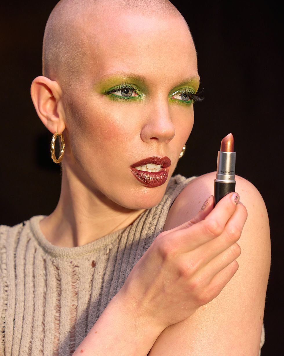 een model poseert met een lipstick in de hand