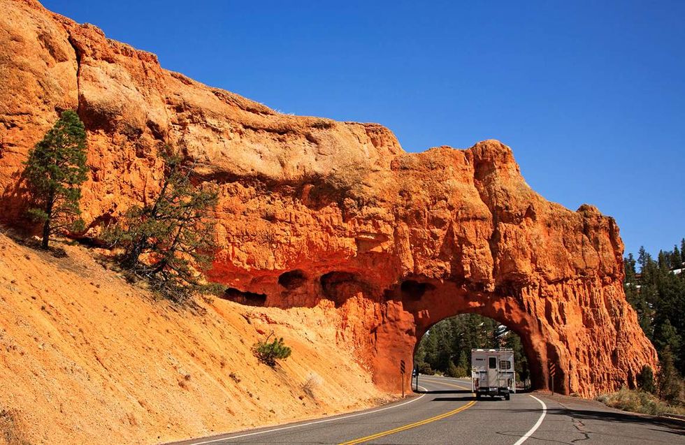 a large rock arch over a road