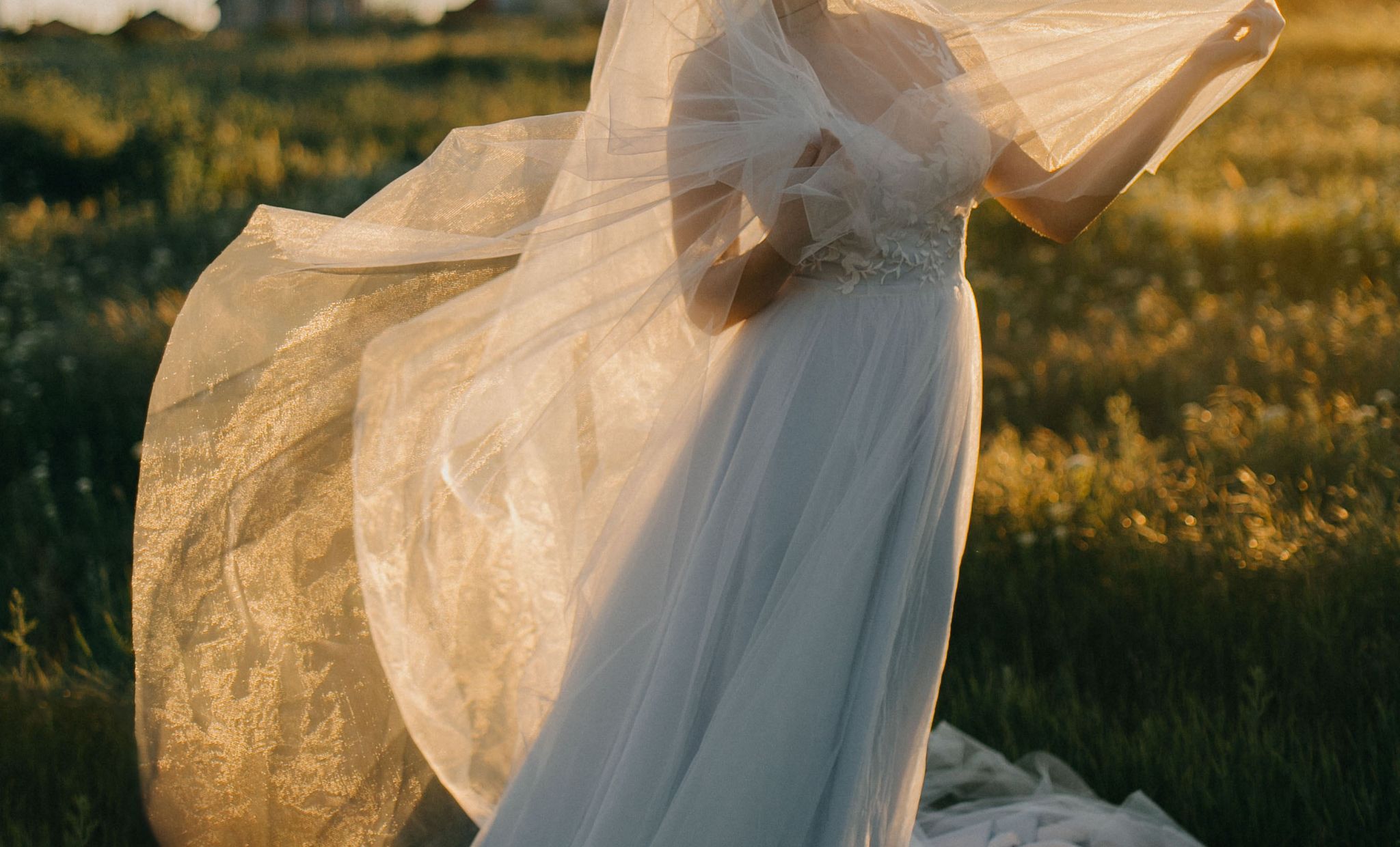 Dress, Wedding dress, Bridal accessory, Veil, Bridal veil, Gown, Bridal clothing, Grass, Sunlight, Photography, 