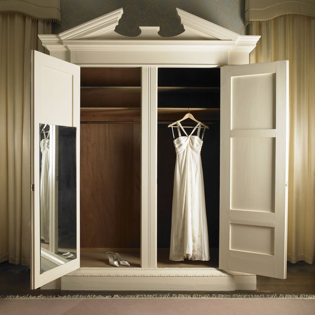 wedding dress hanging in wardrobe with shoes