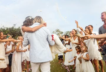 wedding guests tossing rice at newlyweds, outdoors