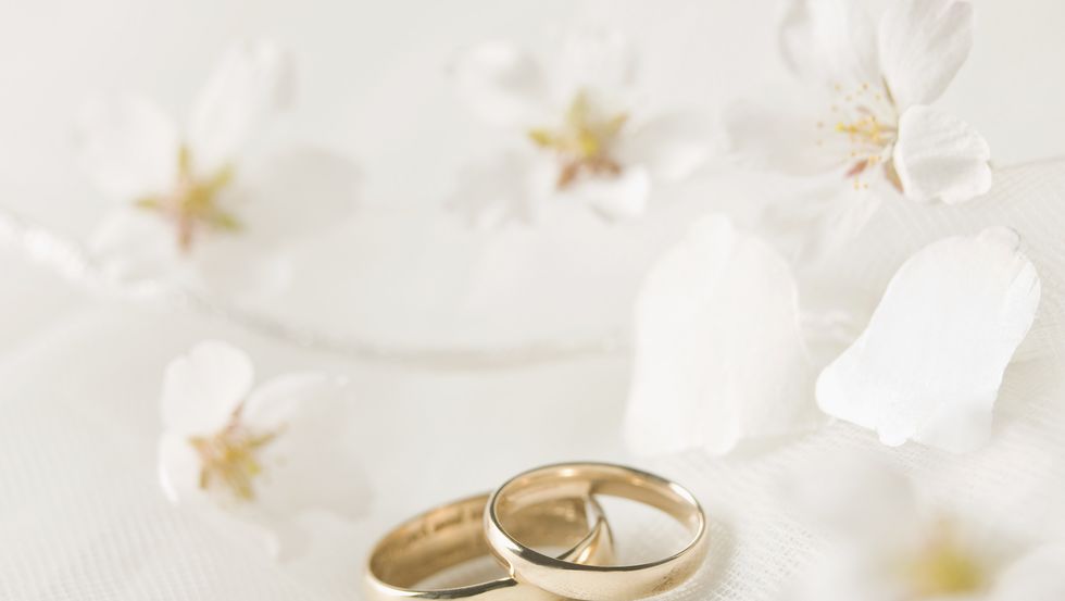 wedding rings against lace, flowers confetti