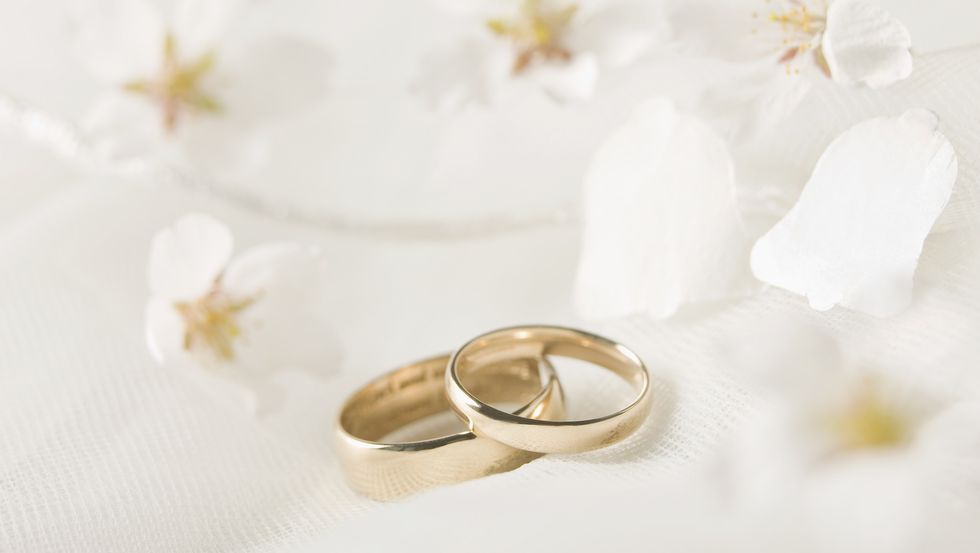 wedding rings against lace, flowers confetti