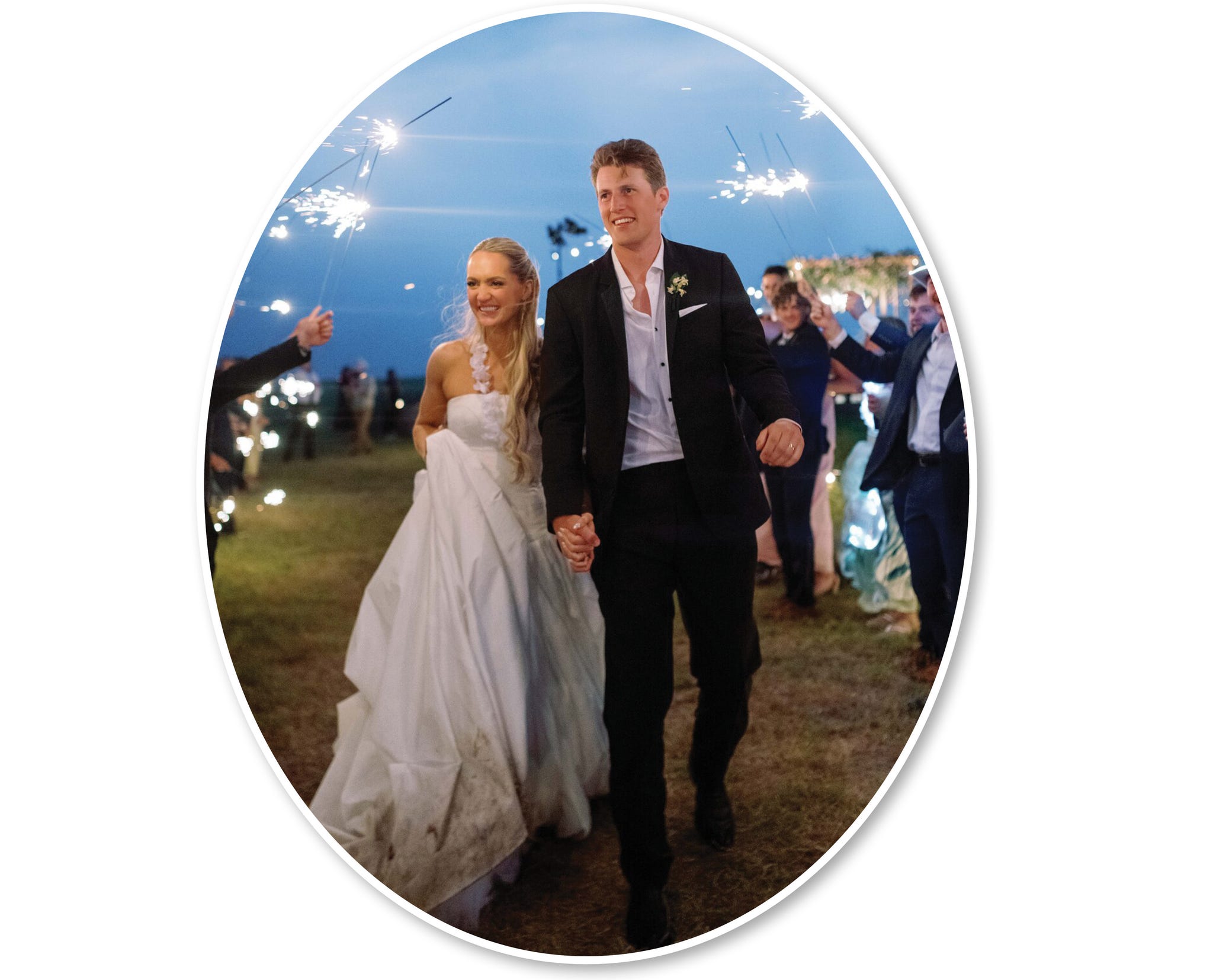 a couple exits a wedding ceremony surrounded by guests holding sparklers