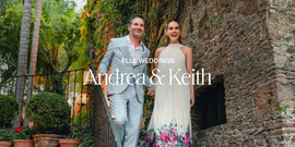 couple in formal attire standing on a stone staircase surrounded by greenery