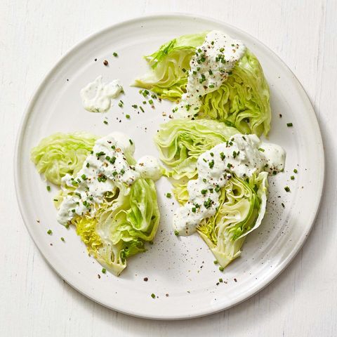 wedge salad with creamy herb dressing on a white plate