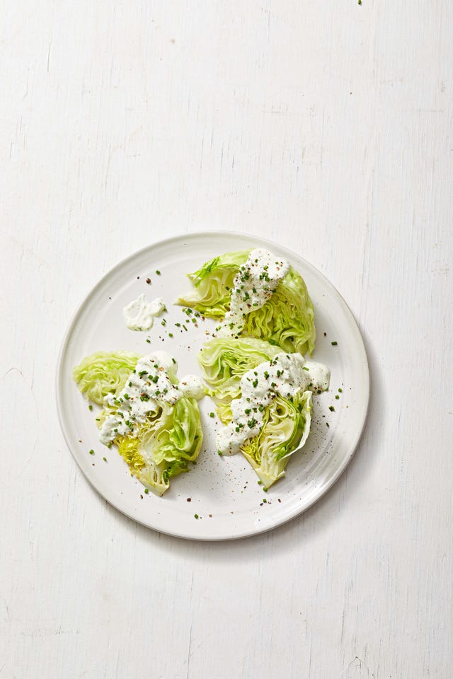 wedge salad with creamy white dressing and fresh herbs on top