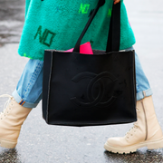 someone walking in boots and carrying a black chanel tote someone walking in boots and carrying a black chanel tote