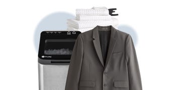 laundryrelated items including a washing machine stacked white towels and a suit jacket