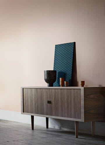 Walnut 'CH825' credenza sideboard by hans J Wegner standing against a peach coloured wall