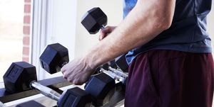 chest exercises, man picking up dumbbells to prepare for chest exercises