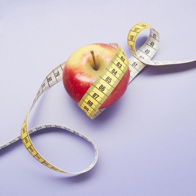 weight loss prevention high angle view of an apple and tape measure on purple background