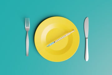 syringe on a yellow plate with knife and fork at each side on green background illustration of the concept of vaccinations and chronic diseases