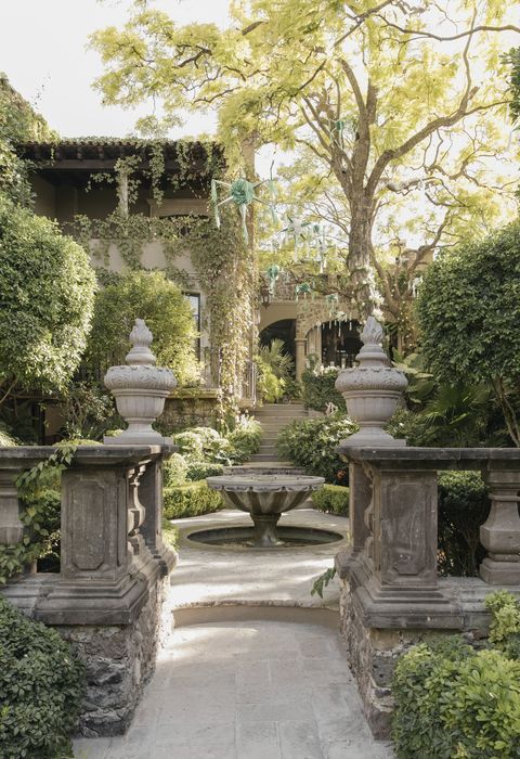 custom urns flank the entrance to a magical middle garden