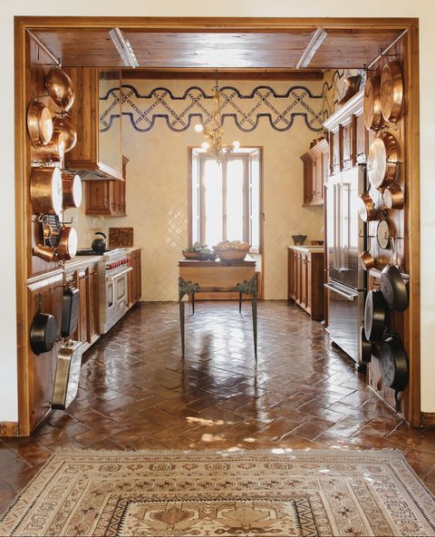 fisher emblazoned the kitchens floor to ceiling tilework with a hand painted border and the flooring is hand burnished local terra cotta