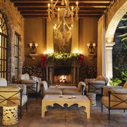 large rope chandeliers and a roaring fire illuminate a cozy sala abierta or outdoor living room