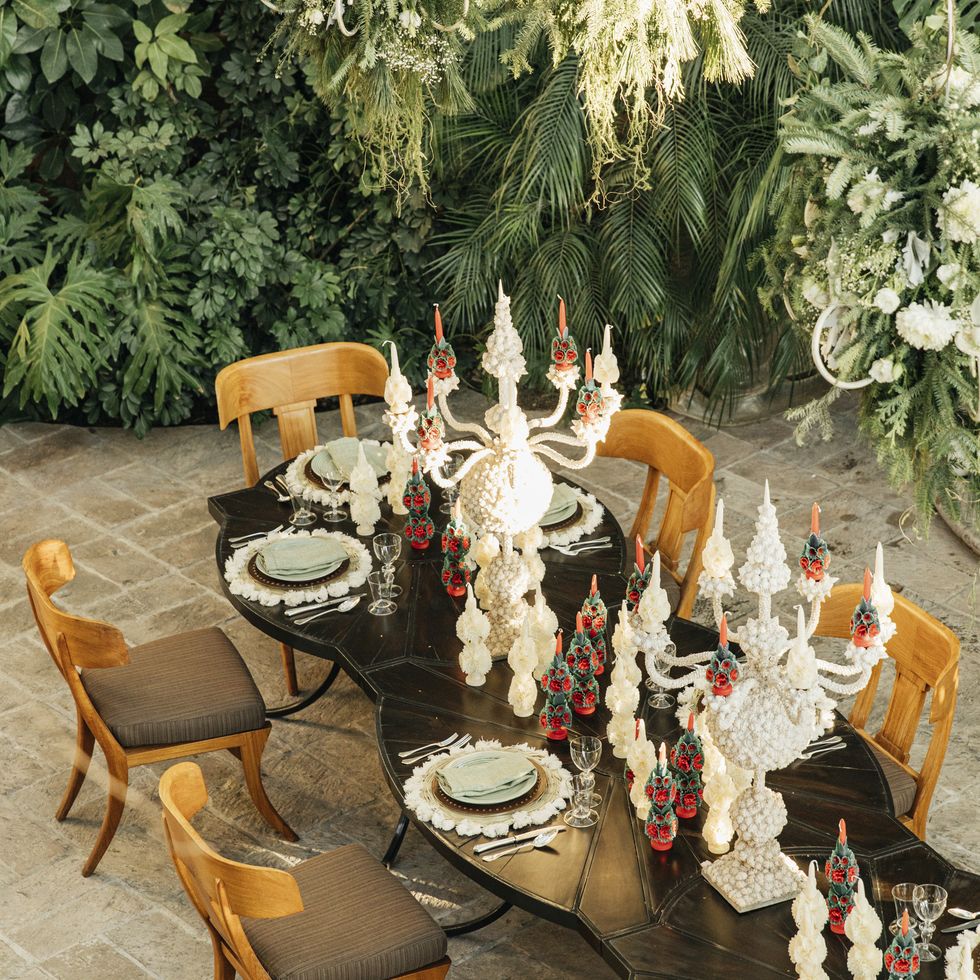 red candles embellished by oaxacan artists and pale green talaveran pottery bring enchanting christmas color to the table
