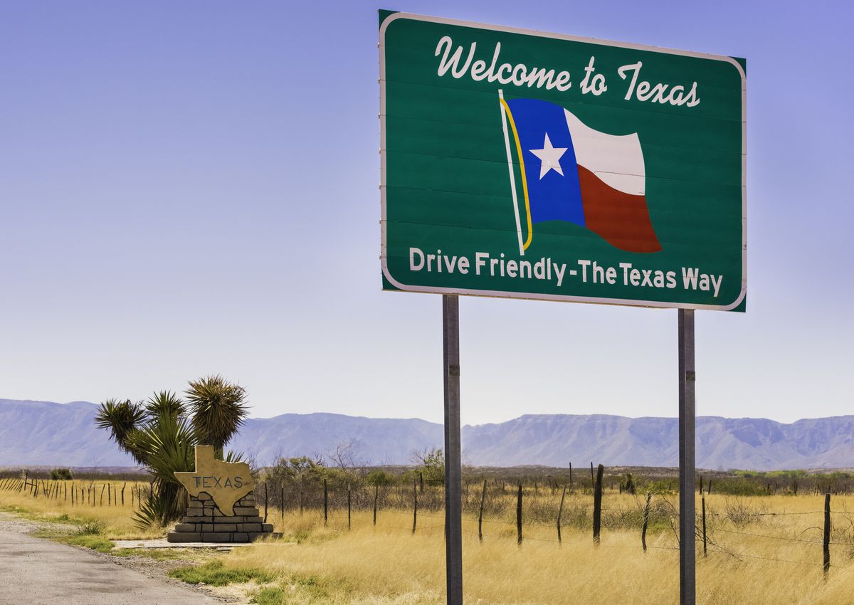 welcome to texas and drive friendly road sign