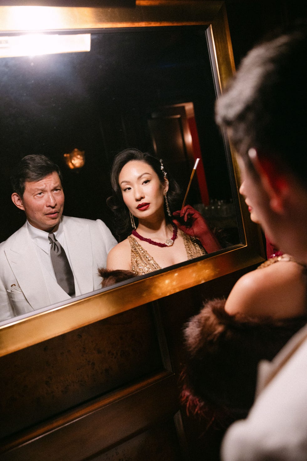 individui elegantemente vestiti in un ambiente che riflette un'atmosfera vintage o glamour