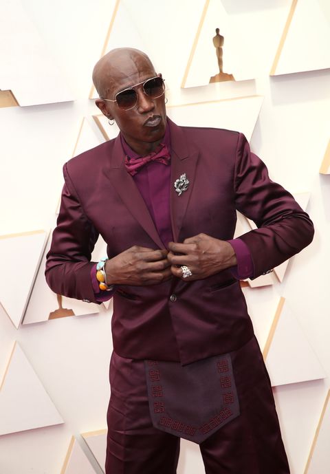 wesley snipes holding his suit while posing for a photograph