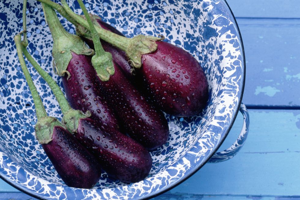 wet eggplants in a blue bowl