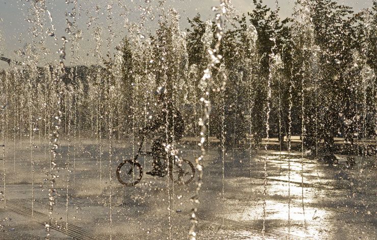 cyclist riding through fountain