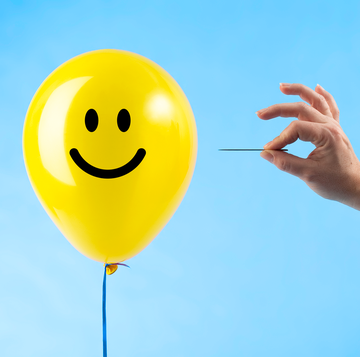 toxic positivity popping yellow balloon with smile face