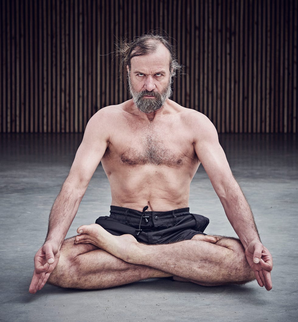 topless male middle aged bearded man sitting crossed legged on the floor