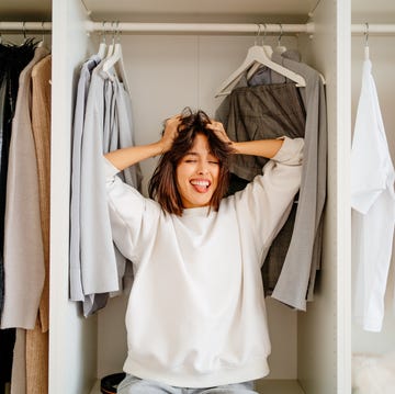 what a mess, clothes outfit problem laughing hysterical female standing in the wardrobe in trouble