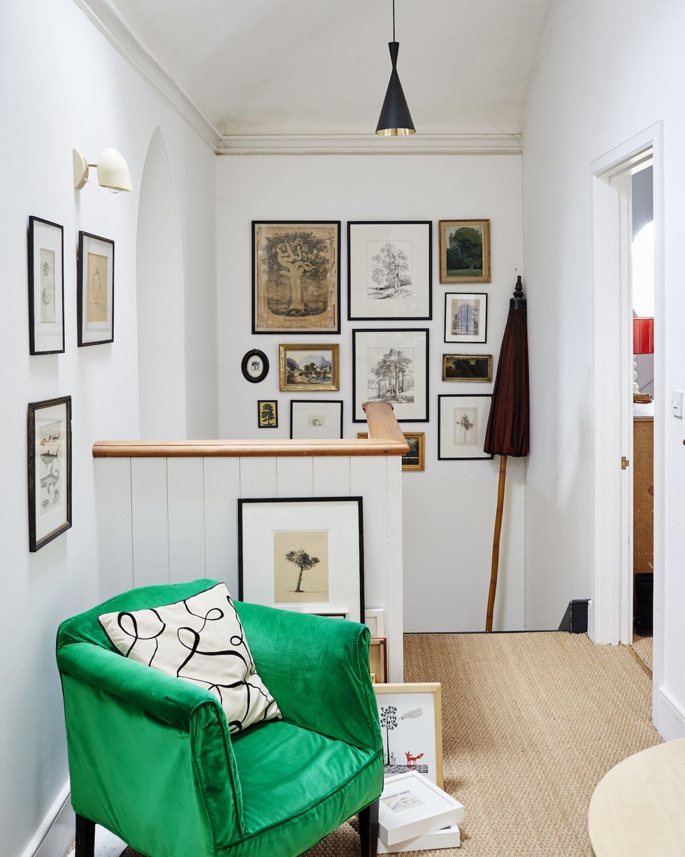 landing of a home with a green antique chair and vintage art