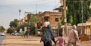 two women and a boy walk along a street in khartoum, the sudanese capital