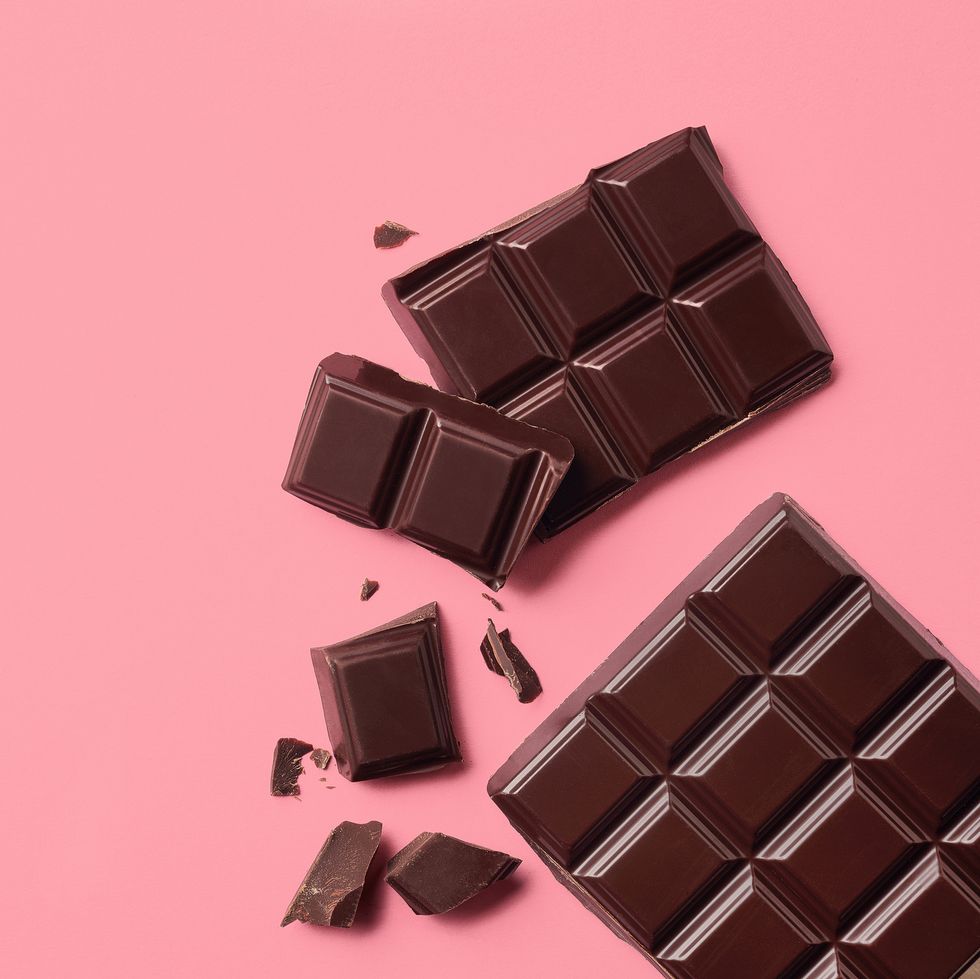 foods to eat during periods for energy dark chocolate on pink background top view