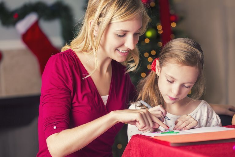 woman and daughter writing in christmas cards