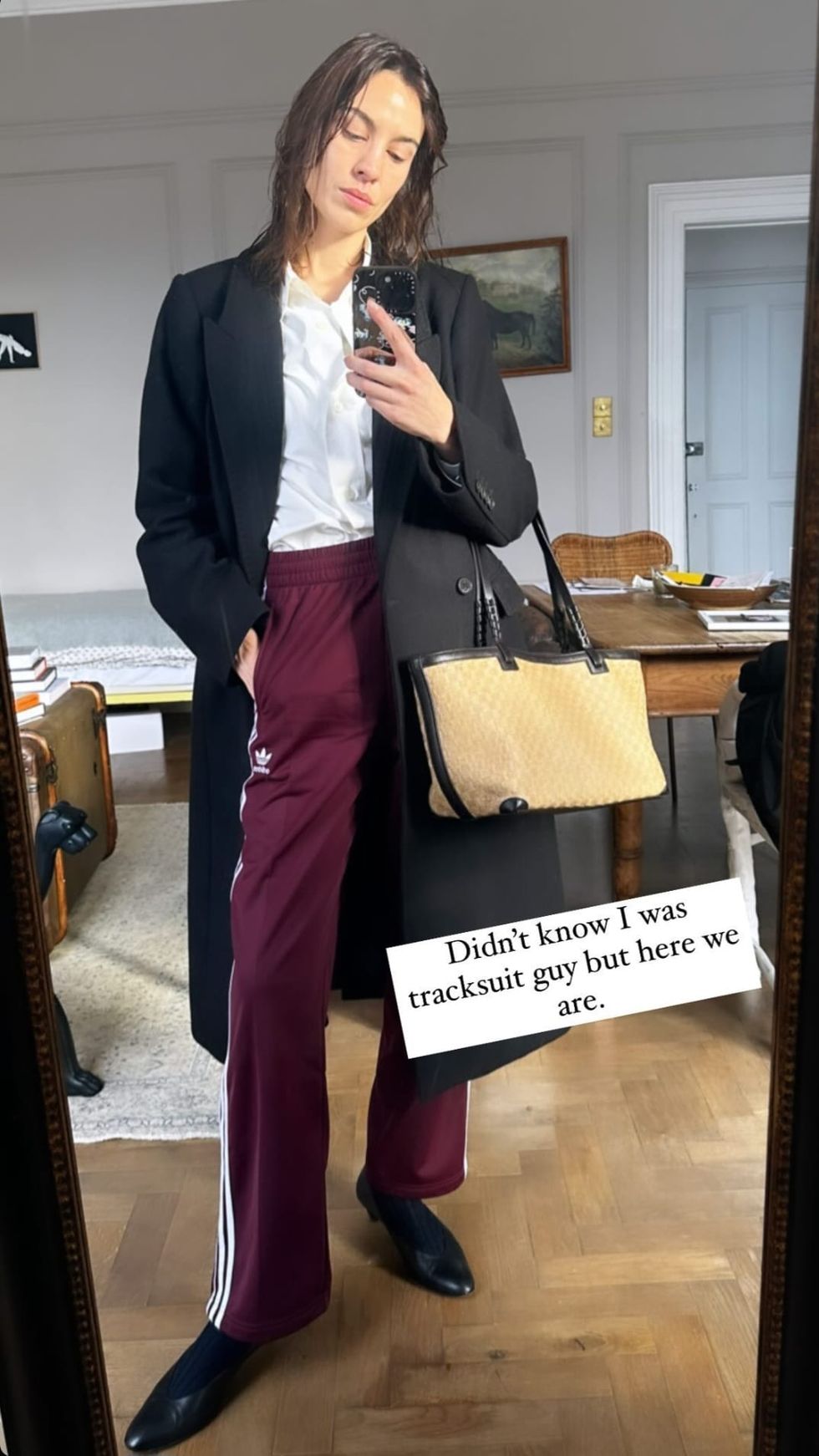 a woman in a suit holding a purse and a bag
