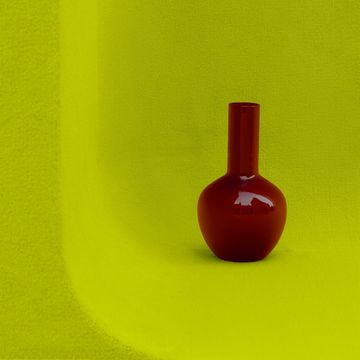 a red candle on a green surface