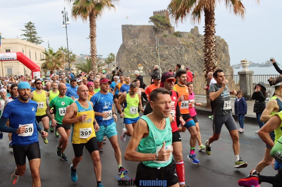 a bustling scene of runners participating in a race surrounded by a coastal setting